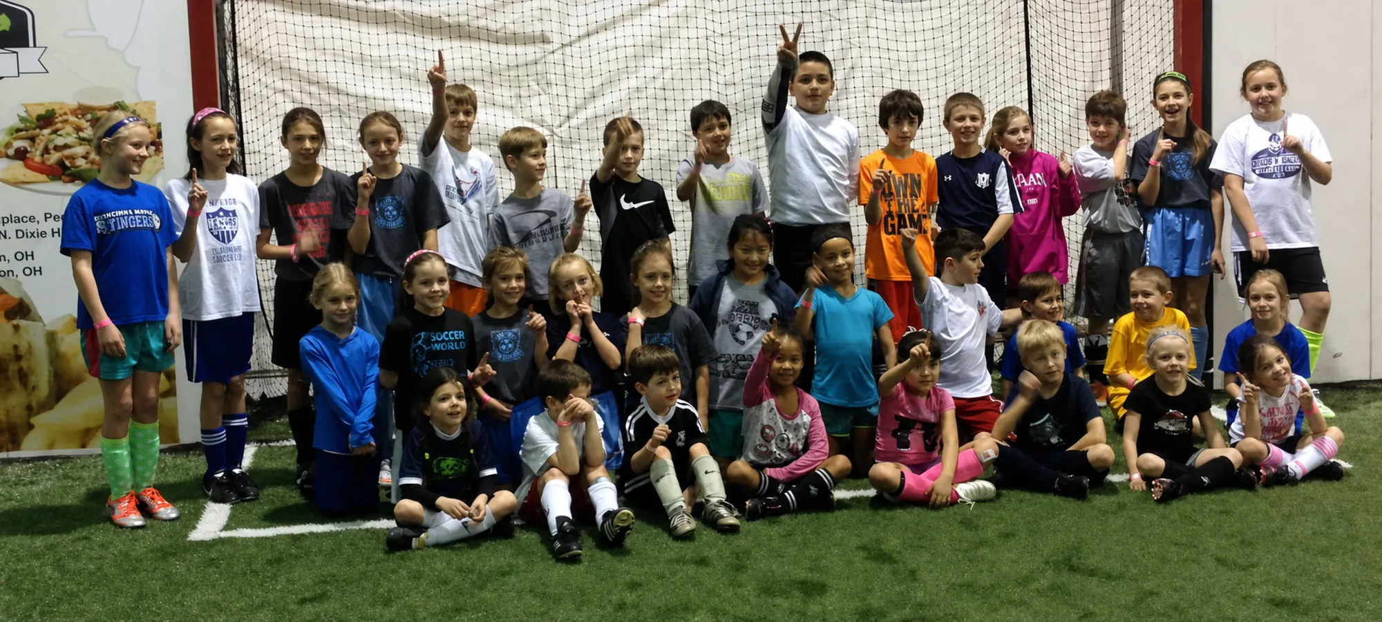 Youth soccer camp players gathered on indoor turf