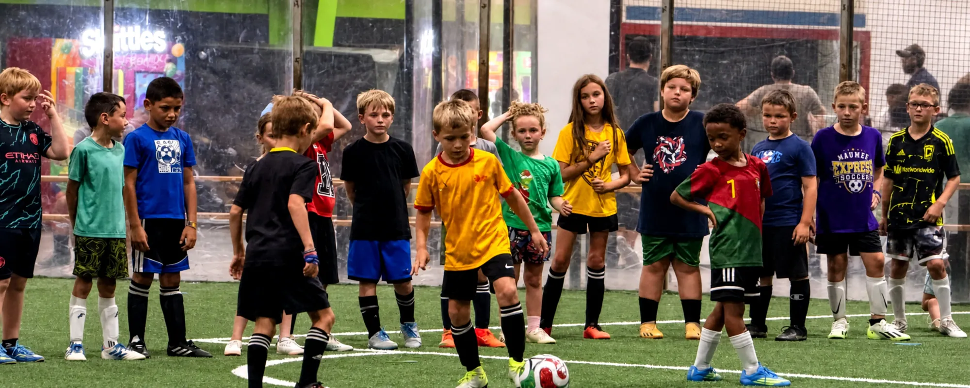 Youth indoor soccer players lined up on the turf